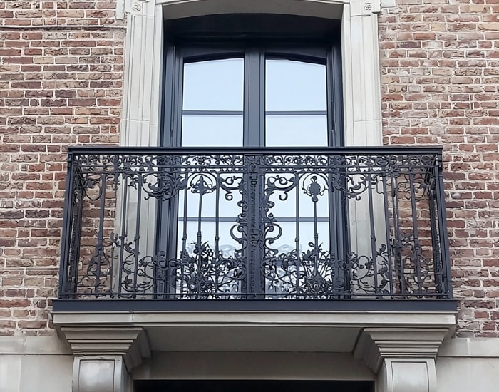 metal ornate french balcony on brick building